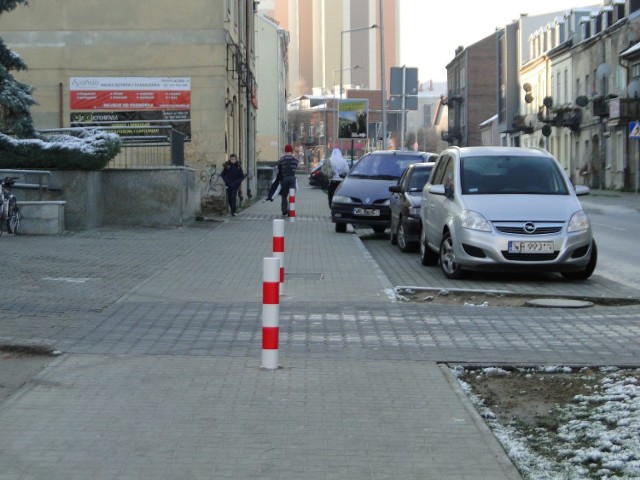 Drogowcy zamontowali słupki na chodniku przed oddziałem Powszechnego Zakładu Ubezpieczeń  przy ulicy Miłej.