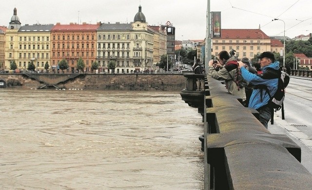 Prażanie i turyści fotografują Wełtawę z mostu Palackého