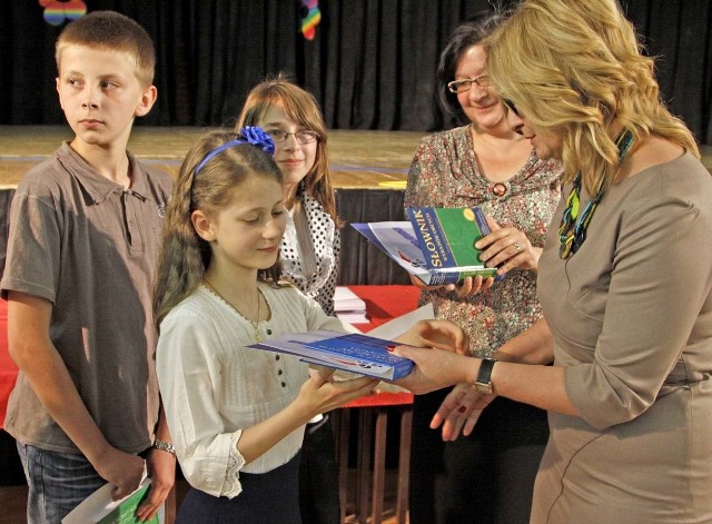 Renata Czapczyńska, dyrektor Powiatowego Ośrodka Poradnictwa Psychologiczno-Pedagogicznego i Doradztwa Metodycznego wręcza nagrody laureatom konkursów przedmiotowych.