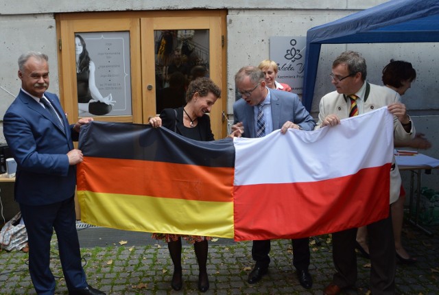 Flagi zszyte na znak przyjaznych 25-letnich relacji polsko-niemieckich. Na zdjęciu autorzy wspólnego ściegu: Stanisław Rakoczy, Sabine Haake, Roman Kolek i Bernard Gaida. 