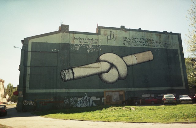 Mural miał nie tylko pomysłowy obrazek jako temat główny, ale i spełniał ważną rolę społeczną - ostrzegał przed zgubnymi efektami palenia papierosów. Reklama została namalowana latem 1987 roku. Pośpiech podyktowany był względami bezpieczeństwa związanymi z wizytą Jana Pawła II w Łodzi - rusztowania musiały zostać zdemontowane przed rozpoczęciem pielgrzymki. Papieros został zamalowany w 1999 roku.