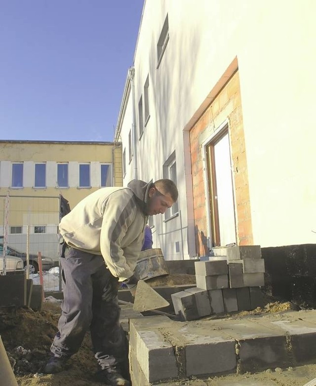 Przemysław Woźny z firmy Dana-Bud muruje schody do wejścia głównego do przyszłego zakładu opiekuńczo-leczniczego (fot. Krzysztof Kubasiewicz)