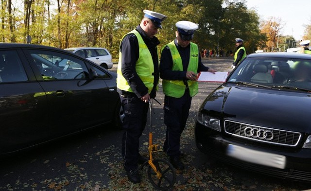 Do potrącenia doszło w niedzielę 1 listopada przy wjeździe na stary cmentarz przy ul. Wrocławskiej. Kierująca audi potrąciła kierującego ruchem policjanta z drogówki. Funkcjonariusz został przewieziony do szpitala.Policjant z drogówki kierował ruchem przy wjeździe na parking starego cmentarza. Zgodnie z ustaleniami mogą tam wjechać tylko osoby z ważną legitymacją inwalidy, ograniczona liczba taksówek oraz osoby dowożące towar do swoich sklepów.Kierowcy niemal co chwilę zatrzymują się i próbują wjechać na parking. Policjanci muszą cały czas wyjaśniać, że nie ma wjazdu na parking starego cmentarza. Takie zachowanie kierowców utrudnia ruch przy cmentarzu.W pewnym momencie do wjazdu podjeżdżało audi. Siedząca za kierownicą samochodu kobieta nie miała uprawnień do wjazdu na parking. Policjant kierujący ruchem na jezdni pokazywał jej , że ma jechać dalej. W pewnym momencie kierując audi wjechała jednak w policjanta potrącając go. - Zobaczyłam, że coś jest nie tak, policjant trzymał się za nogę - opowiada jedna z osób handlujących zniczami przy wjeździe.Na miejsce został wezwana karetka pogotowia ratunkowego. Policjant z drogówki został przewieziony do szpitala na badania. Wiadomo już, że doznał urazu stopy i stłuczenia kolana. Kierując audi dostała mandat w wysokości 500 zł i 6 punków karnych za spowodowanie kolizji.