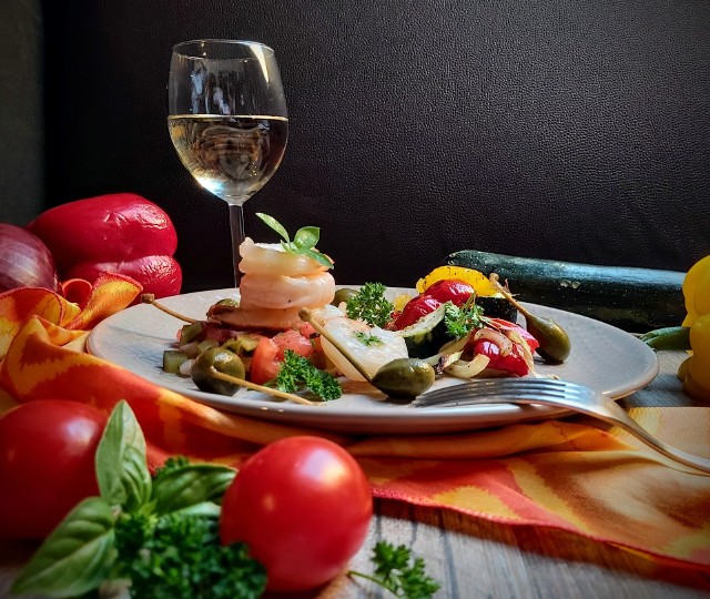 Krewetki na aromatycznych pieczonych warzywach to pomysł na romantyczną kolację we dwoje w śródziemnomorskim klimacie. Zobacz przepis.