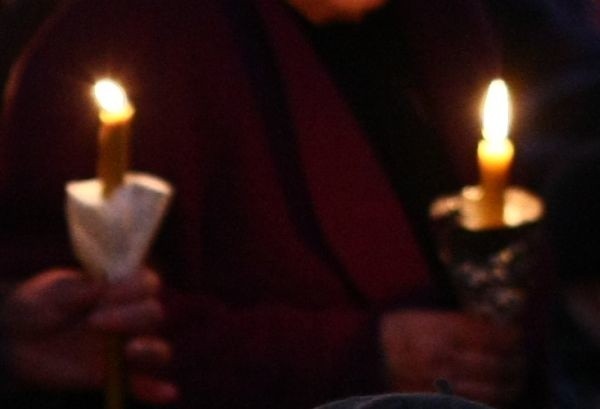Wierni podczas odczytywania fragmentów Ewangelii trzymają zapalone świece