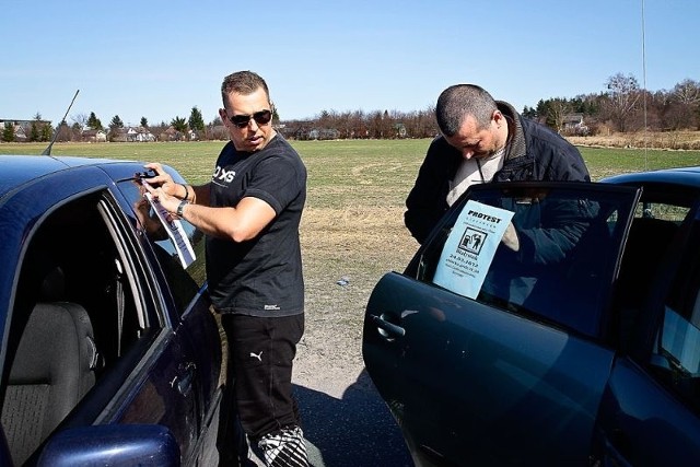 Przygotowania do protestu. Kierowcy nalepiają plakaty informacyjne na szyby swoich aut.