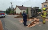 Przewrócona ciężarówka leży na drodze w Woli Radłowskiej pod Tarnowem. Wcześniej pojazd zderzył się z osobowym BMW i wjechał w płot 
