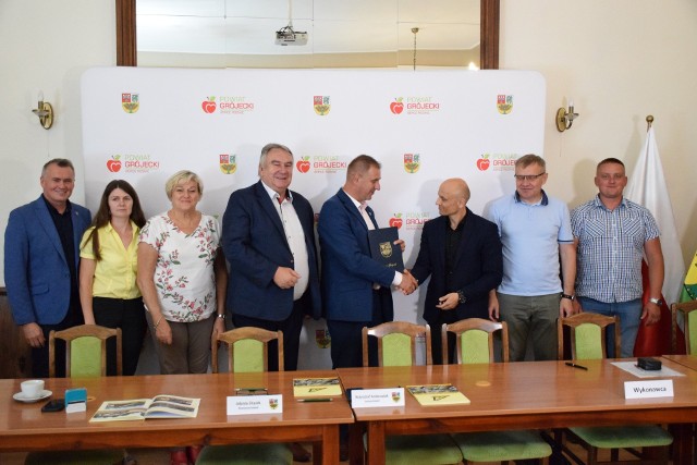 Krzysztof Ambroziak, starosta grójecki, członkowie Zarządu Powiatu i przedstawiciele samorządów gminnych i wykonawców na podpisaniu umów.