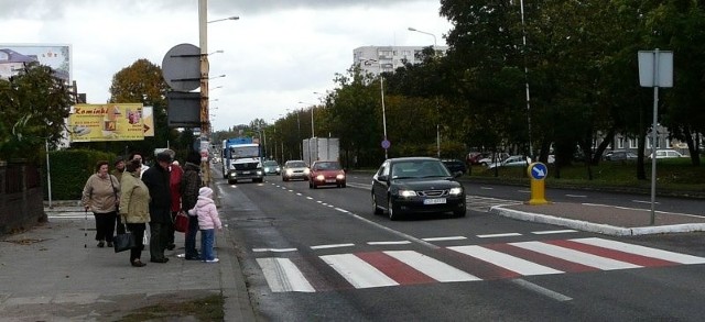 Obok przejścia dla pieszych przy skrzyżowaniu z ulicą Nowakowskiego jest przystanek. Na zdjęciu pasażerowie, którzy wysiedli z autobusu. Żaden z kierowców nie zatrzymał się, by przepuścić ich przez jezdnię.