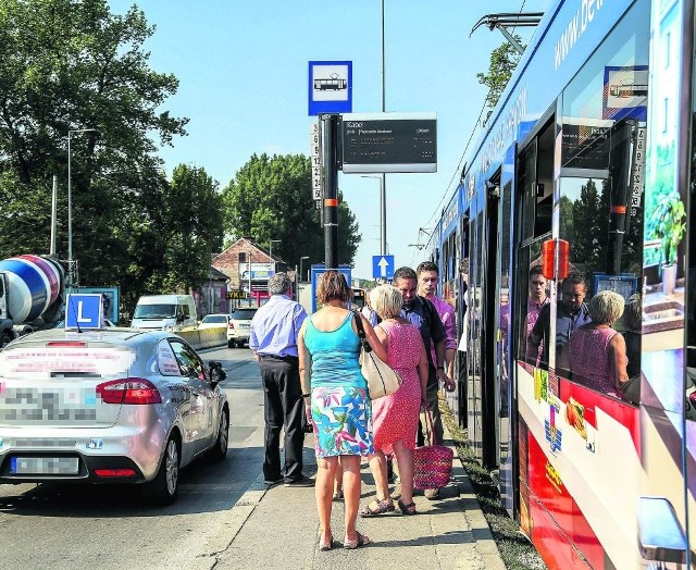 Pasażerowie tłoczą się na niewielkiej powierzchni pomiędzy tramwajami i ruchliwą jezdnią