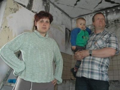 Barbara i Adam Koziołowie z 2-letnim Kacperkiem w spalonym w pożarze pokoju gościnnym.