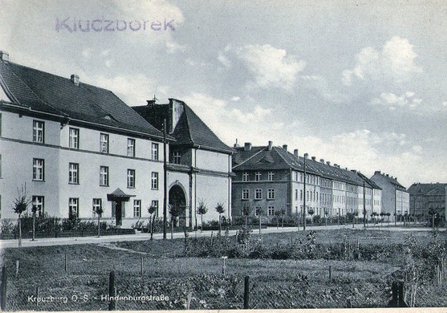 Kluczborska poniemiecka pocztówka. U góry jest polska nazwa Kluczborek, a na dole niemiecka nazwa ulicy Hindenburgstrasse. Na widokówce widać budynki przy dzisiejszej ul. Sienkiewicza (do 1945 r. - Hindenburgstrasse).