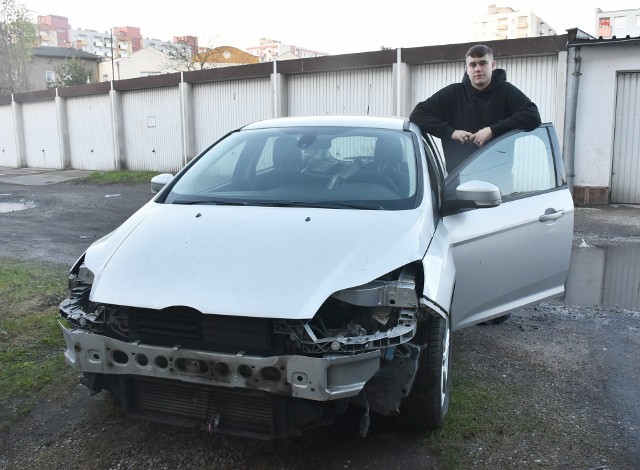 Bartłomiej Dłużniewski ze swoim samochodem "uziemionym" przy bloku.