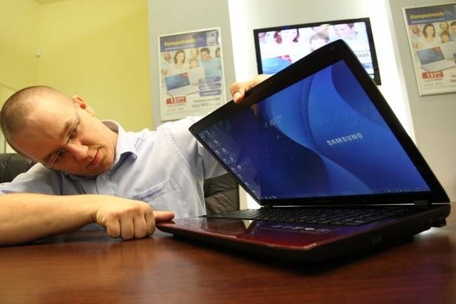 Łukasz Skibicki, kierownik salonu Komputronik, prezentuje jeden z modeli laptopów marki Samsung.