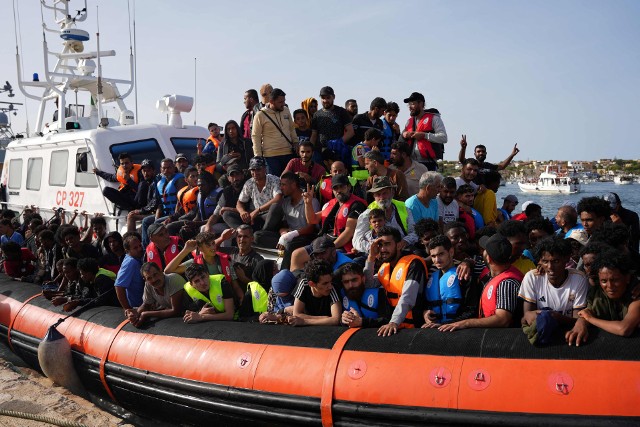 Migranci na łodzi ratunkowej przybyłej na Lampedusę
