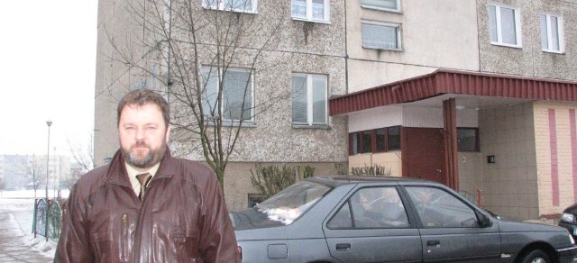 Prezes suwalskiej spółdzielni Tadusz Szymańczyk przed klatką schodową bloku