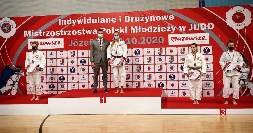 Trener Radosław Miśkiewicz ze swoimi zawodniczkami na podium...