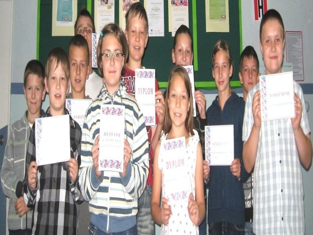 Uczniowie podstawówki w Wiślicy, z Majką Białkiewicz (w środku), udali się na wakacje w świetnych humorach &#8211; zdobyli "górę trofeów&#8221; w międzynarodowym konkursie Kangur Matematyczny dla młodzieży. 