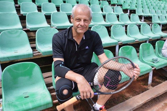 Ksiądz Andrzej Maczuga na widowni kortu tenisowego w Stalowej Woli, gdzie przyjeżdża na treningi z miejscowymi tenisistami.
