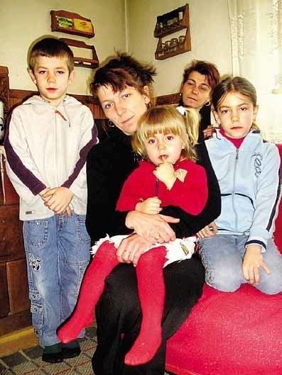 Pani Agnieszka trzyma na kolanach najmłodszą córkę Kingę, po lewej stoi Dominik,  z prawej  - Żaneta.