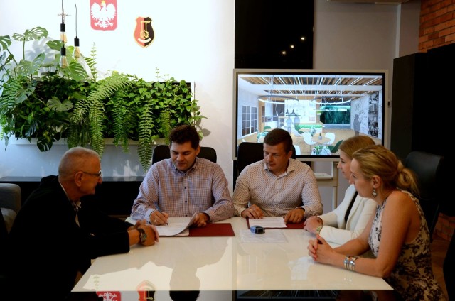 Prezydent Lucjusz Nadberezny podpisuje umowę na centrum z wykonawcą, w towarzystwie przedstawiciela seniorów