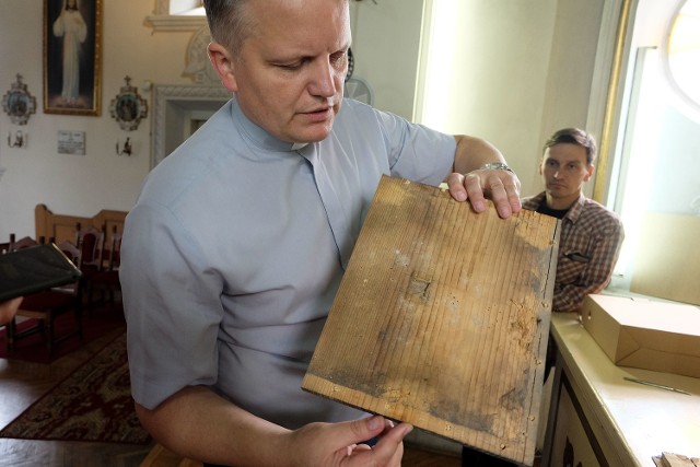 Schowano tu relikwie trzech męczenników - pokazuje portatyl ks. Andrzej Chutkowski. Obok stoi Maciej Dąbrowski , konserwator