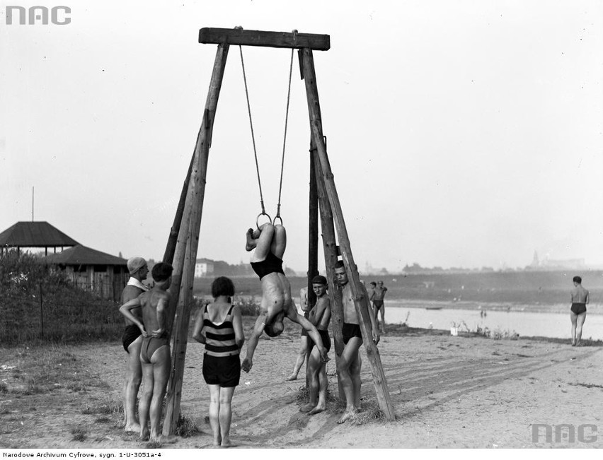 Plażowicze przy kółkach gimnastycznych.