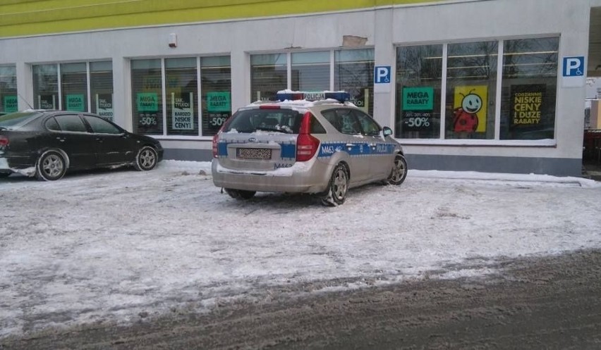 Policyjny radiowóz zaparkowany przed sklepem sieci Biedronka...