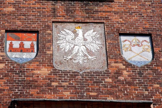 Dwie tarcze tworzące współczesny herb Kołobrzegu zobaczyć można na wieży ratusza. Trafiły tam w XIX wieku, od 1945 roku rozdziela je godło państwowe. 