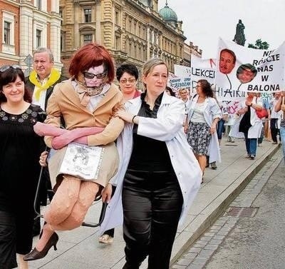 Pracownicy niosą kukłę Marzeny Grochowskiej, dyrektorki szpitala Fot. Anna Kaczmarz