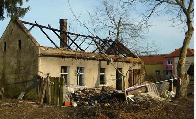 Palił się opuszczony dom w Praszce. W tle widać szkołę podstawową nr 4.