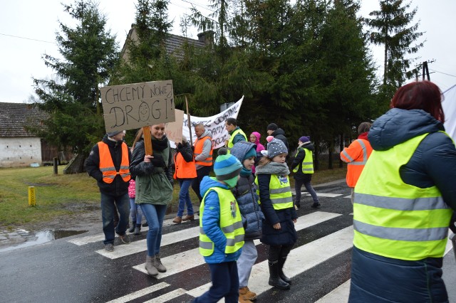 W piątek, 15 grudnia, wyszli z transparentami na ulicę, by domagać się dawno obiecanego remontu drogi relacji Miodnica - Nowogród Bobrzański.Tak mieszkańcy Miodnicy tak protestowali przeciwko  obietnicami Zarządu Dróg Wojewódzkich i przeciągającemu się rozpoczęciu remontu drogi relacji Żagań- Nowogród Bobrzański.  Przyszli z banerami i transparentami. - Po wielu interwencjach nic nie wskóraliśmy, niech widzą, że w nas jest siła, nie odpuścimy. Boimy się tędy chodzić, bo na całej długości drogi nie ma chodnika. By odprowadzić dzieci na autobus, robimy rodzicielskie dyżury, bo nie da się przejść. Sama z maleńką córką w wózku chodziłam odprowadzać syna na autobus. Biegłam, od samego domu, by nie spotkać się z samochodem. Jak napada śnieg nie ma gdzie uciec. To jest dramat naszej wsi! Ale mamy wyrozumiałych kierowców, przepuszczają nas. - Popieramy ten protest - mówią z Grażyna i Mieczysław Remin z Gorzupii oczekujący w samochodzie na przejazd przed przejściem na którym blokowany był  ruch. - Droga jest tak fatalna, że u siebie słyszymy, jak w Miodnicy przejeżdżają ciężarówki z ładunkiem.   -  Droga jest w coraz gorszym stanie. - Obiecywano nam jej remont w tym roku - mówi radny Leszek Ochrymczuk.-  A rok się kończy. Wiemy,  ze w przyszłym też się go nie doczekamy. Ruch utrudniają koleiny, nie ma chodnika. Tu nawet dorośli boją się chodzić. Jest bardzo niebezpiecznie. Paweł Tonder,  dyrektor Zarządu Dróg Wojewódzkich przyznaje, że inwestycja jest wpisana w  plan inwestycyjny na przyszły rok. - Wiemy, że droga jest w bardzo złym stanie, jednak szacunkowe koszty  wykonania, tj. 28 mln zł, znacznie przekraczają nasze możliwości. Pierwotnie planowaliśmy przeznaczyć na ten remont 10 mln zł, teraz okazuje się,że tyle ma kosztować wyłącznie kanalizacja deszczowa. A remont przewiduje też budowę chodników na całej długości jezdni, która ma mieć szerokość 7 m i  przebudowę mostu. To niewyobrażalnie duża kwota. Będziemy ją jeszcze weryfikować, ponieważ wykonawca dokumentacji, którą zleciliśmy w 2014 roku spóźnia się z jej domknięciem. Na jej opracowanie miał dwa lata. Od stycznia tego roku naliczamy więc kary umowne.Czytaj też: Sceny grozy na przejeździe kolejowym w Nowogrodzie Bobrzańskim. Auta stają między rogatkami