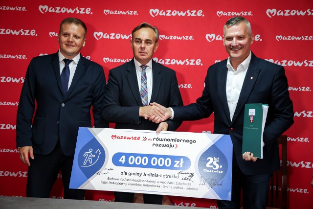Burmistrz Jedlni-Letnisko Piotr Leśnowolski (w środku) otrzymał symboliczny czek z rąk wicemarszałka Mazowsza Rafała Rajkowskiego (z prawej).