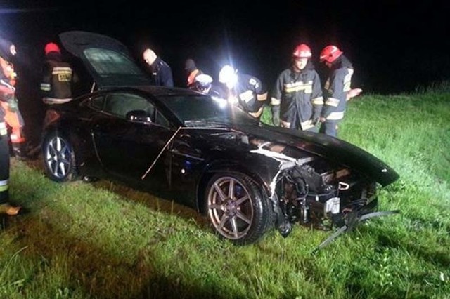 Aston Martin ma uszkodzony przód. Strażakom udało się wyciągnąć auto ze stawu.