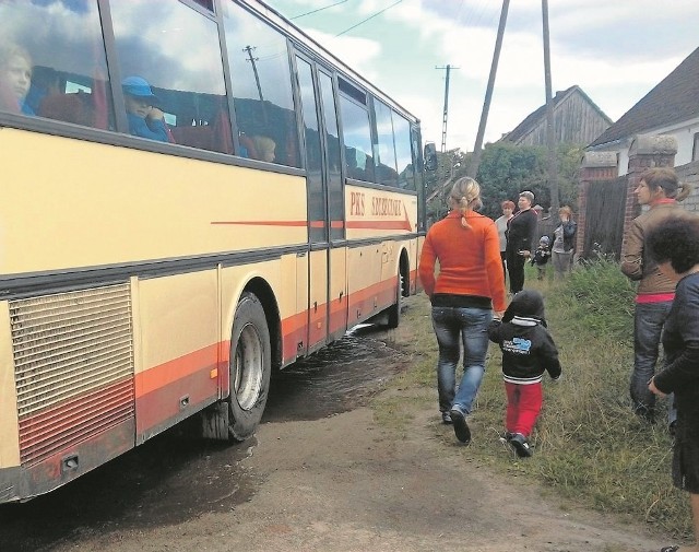 Autobus PKS koło przystanku w Krosinie wysadza pasażerów wprost w wielką kałużę.