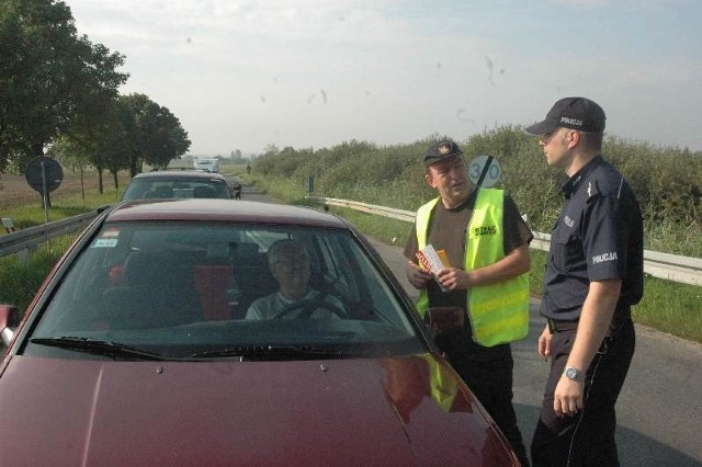 Adam Grajek ze Służby Ochrony Kolei i policjant Robert Łojek wręczali kierowcom ulotki zachowaniu ostrożność na przejazdach kolejowych