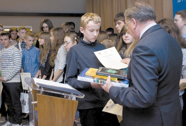 Jakub Ficek odbiera nagrodę za pierwsze miejsce wśród gimnazjalistów.