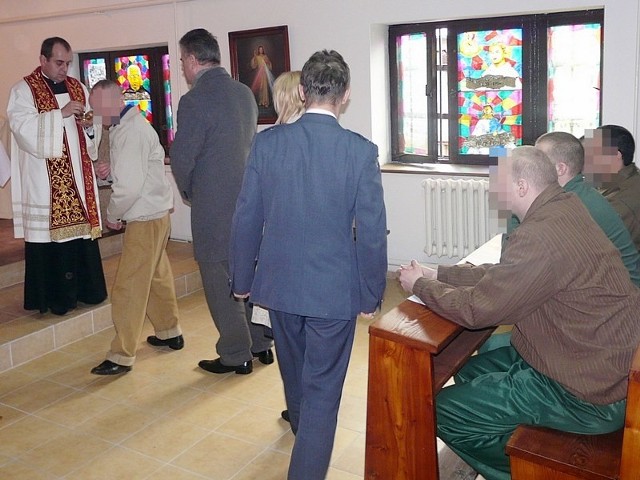 Ksiądz Łukasz udziela komunii św. więźniom i gościom przybyłym na otwarcie i poświęcenie kaplicy.