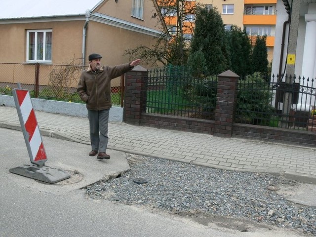 Wiesław Dec pokazuje uszkodzoną drogę przed swoim domem przy ulicy Chopina w Tarnobrzegu.  