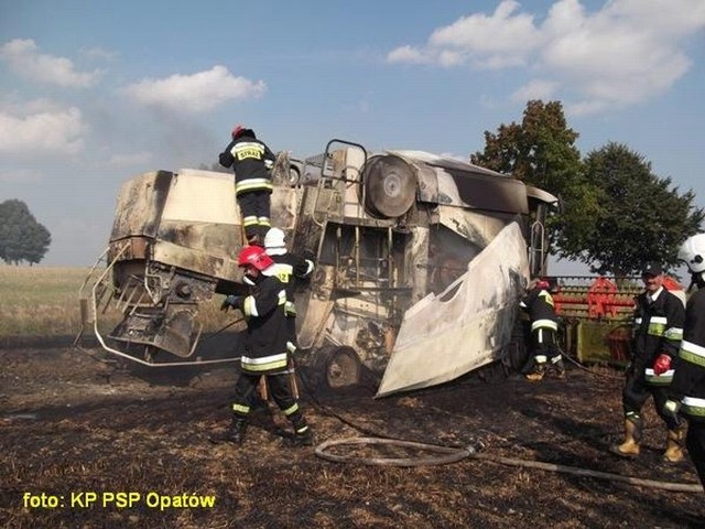 Strażacy dogaszają pożar kombajnu na polu w Bidzinach.