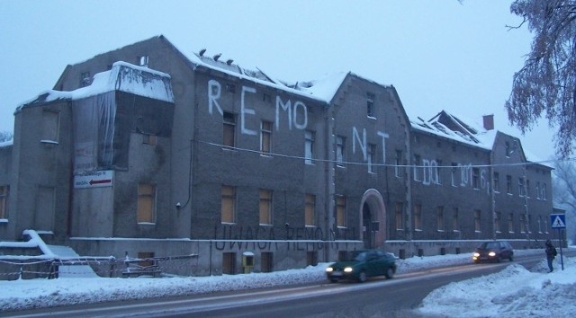 Stary szpital w Oleśnie bez dachu i z wielkim napisem na ścianie.