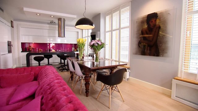 Salon połączony z kuchniąŁącznikiem między salonem i kuchnią jest odważny różowy kolor.