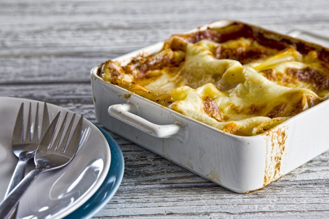 Składniki:Makaron LasagneMozarella (2 kule)Tarty parmezan (100g)Ricotta (100g)Gałka muszkatołowaSól, pieprzPomidory w puszce (1 op.)Czosnek (2 ząbki)Cebula (2 szt.)Oregano suszoneCukier brązowyOliwaMasło (100g)Mąka Lubella Puszysta Poznańska (100g)Mleko (500ml)Przygotowanie:Makaron obgotowujemy. Ricottę mieszamy z parmezanem i doprawiamy gałką muszkatołową, solą oraz pieprzem. Tak przygotowany farsz nakładamy na połowę płata makaronu, następnie na każdej z nich układamy po kawałku mozarellii składamy na pół.Masło roztapiamy i przesmażamy na nim mąkę, następnie dolewamy mleko cały czas mieszając by powstał beszamel. Doprawiamy solą, pieprzem i gałką muszkatołową.Na patelni przesmażamy na oliwie posiekany czosnek i cebule, a następnie dodajemy pomidory. Doprawiamy solą, pieprzem, oregano i brązowym cukrem do smaku, tak by sos był lekko słodki.Do formy do zapiekania nalewamy sos pomidorowy i układamy makaronowe koperty, a następnie przykrywamy całość gęstym beszamelem i zapiekamy przez 30 minut w piekarniku nagrzanym do 180 stopni.