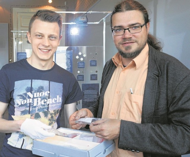 Piotr Niziołek (z lewej) i Adam Wawrusiewicz przeglądają odnalezione monety