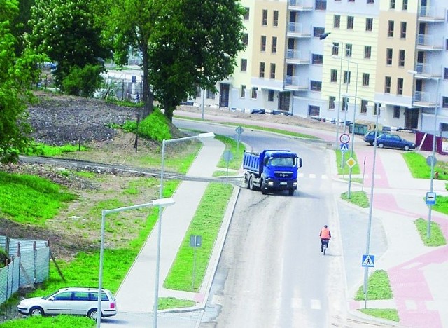 Obłocone ciężarówki z budowy stadionu powiatowego wyjeżdżają na ulicę Tuwima.