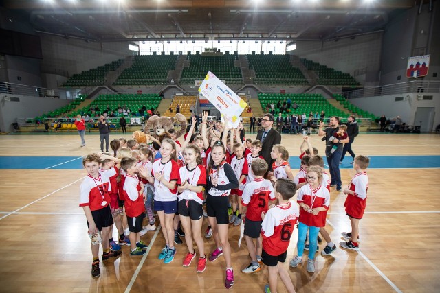 Reprezentacja SP 28 z Torunia najlepsza w wojewódzkim finale Sprawnego Misia! W poniedziałek w bydgoskiej hali Łuczniczka w pięknym stylu wygrała turniej miast. Na podium stanęli także uczniowie SP 37 z Bydgoszczy i SP 6 z Inowrocławia. Finał odbył się w bydgoskiej hali "Łuczniczka". - Po raz trzeci rozgrywamy go w składzie pięciu miast naszego regionu, z udziałem najlepszych młodych sportowców z Bydgoszczy. Torunia, Inowrocławia, Włocławka i Grudziądza. Nie wiem, kto będzie najlepszy, ale jestem pewien, że emocji w tym turnieju nam nie zabraknie - mówił tuż przed rozpoczęciem rywalizacji Wojciech Potocki, redaktor naczelny "Gazety Pomorskiej".Nie mylił się - każda z pięciu reprezentacji doskonale przygotowała się do zawodów i od pierwszej do ostatniej konkurencji trwała zacięta walka o każdy punkt. Już w pierwszej rundzie wyklarował się jednak faworyt - SP 28 z Torunia wygrywała konkurencję za konkurencją. Po pierwszej rundzie, w której walczyli uczniowie klas I, miała komplet  30 punktów. Po drugiej serii startów (klas II) - podwoiła swój punktowy dorobek. Na półmetku, miała już taką przewagę, że zwycięstwo miała już na wyciągnięcie ręki. Rywale za punkt honoru postawili sobie jednak pościg za liderami. W końcówce trzeciej serii rywalizacja się wyrównała. Pierwsze zwycięstwo zanotowała SP 37 z Bydgoszczy, debiutująca w wojewódzkim finale. Znakomicie spisywali się uczniowie inowrocławskiej "szóstki", mocno gonili uczniowie z SP 23 z Włocławka, a reprezentacja SP 5 z Grudziądza zaczęła odrabiać straty z pierwszych serii. W rywalizacji klas IV znów najskuteczniejsi byli uczniowie z Torunia. W tej serii rywalom "oddali" tylko 2 punkty i praktycznie zapewnili sobie triumf w finale. - Świetnie nam poszło, sami chyba nie przypuszczaliśmy, że pójdzie nam tak gładko - cieszyła się Elżbieta Mućka, jedna z opiekunek-trenerek uczniów SP 28. - Trafiliśmy w szkole na doskonałe roczniki. Nie mamy wcale dużo dzieci, ale są naprawdę świetne. Do turnieju przygotowywaliśmy się tak, jak co roku. Pod koniec poprzedniego rozpoczęliśmy treningi do miejskiej rywalizacji, którą w ostatnich latach niemal regularnie wygrywamy. Potem podszlifowaliśmy trochę formę przed finałem wojewódzkim. Najbardziej obawialiśmy się szkoły z Bydgoszczy, bo zwykle między nami toczyła się najbardziej zacięta walka. Cieszę się, że udało nam się wygrać.To drugie zwycięstwo z Torunia w finale wojewódzkim rozgrywanym w składzie pięciu miast. Poprzednio torunianie wygrali dwa lata temu, we Włocławku.Do końca turnieju toczyła się zacięta walka o pozostałe miejsca, ale też o każdy punkt. Bo nikt nie odpuszczał, nawet gdy szans na podium już nie było. Ostatecznie, wicemistrzostwo województwa wywalczyli uczniowie z Bydgoszczy, a trzecie miejsce szkoła z Inowrocławia. Wyniki finału Sprawny Miś 1. miejsce - SP 28 Toruń - 140 punktów (10,10,10,10,10,10,10,10,8,10,8,10,6,10,8)2. miejsce - SP 37 Bydgoszcz - 105 punktów (6,8,4,4,4,8,8,8,10,7,4,6,10,8,10)3. miejsce - SP 6 Inowrocław - 82 punkty (8,4,7,8,8,2,6,4,2,7,10,8,2,2,4)4. miejsce- SP 23 Włocławek - 75 punktów (4,6,7,6,6,6,2,6,6,2,6,4,4,4,6)5. miejsce - SP 5 Grudziądz - 48 punktów (2,2,2,2,2,4,4,2,4,4,2,2,8,6,2)Wszyscy uczestnicy finału otrzymali pamiątkowe medale. Do szkół trafiły oczywiście pluszowe misie (symbole naszego turnieju), dyplomy, puchary i nagrody. Wręczali je: Marek Ciesielski - prezes Polska Press Bydgoszcz, wydawcy „Gazety Pomorskiej”, Alicja Polewska-Matusewicz i Tomasz Pietraszak - zastępcy redaktora naczelnego „GP”, Adam Soroko - zastępca dyrektora Wydziału Sportu i Edukacji UM Bydgoszczy, dr Barbara Moraczewska - zastępca prezydenta Włocławka, Waldemar Olter - rzecznik prasowy oddziału bydgoskiego Enei Operator, Lena Kosiorek - dyrektor CH Rondo, Jacek Rutkowski - prezes Mat-Bud Sp. Z o.o., Krzysztof Kozłowski - prezes Zakładów Chemicznych Nitro-Chem S.A., Karolina Bałuka - dyrektor administracyjny Envio Group Sp. z o.o. oraz Joanna Sobczak i Agnieszka Borowska, przedstawicielki firmy Cronimet PL. 