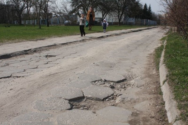 Zrujnowaną ulicą Kalcytową w Kielcach opiekunowie dowożą dzieci do przedszkola.