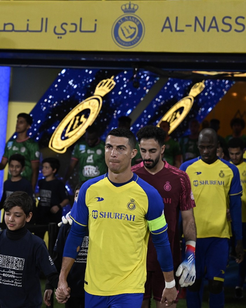 Kapitan Al-Nassr Cristiano Ronaldo wyprowadza swoich kolegów...