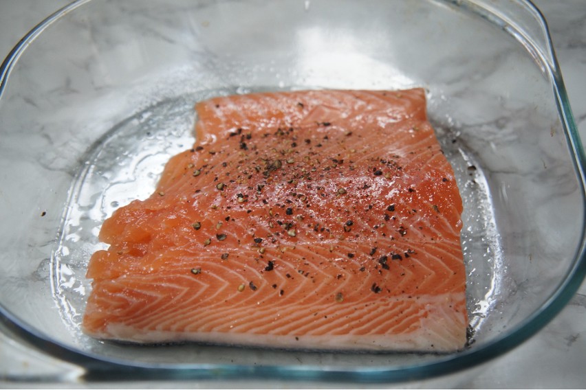 Przed pieczeniem należy doprawić rybę solą i pieprzem.
