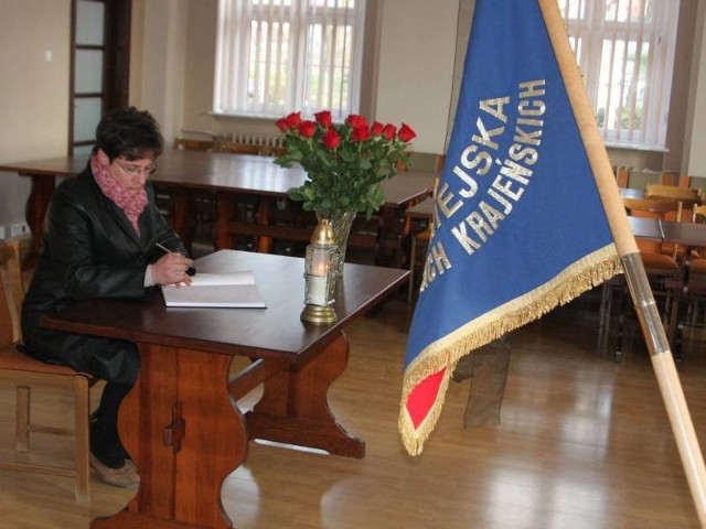Iwona Jakubik wpisuje się do księgi kondolencyjnej, którą wyłożono w sali sesyjnej urzędu miasta.